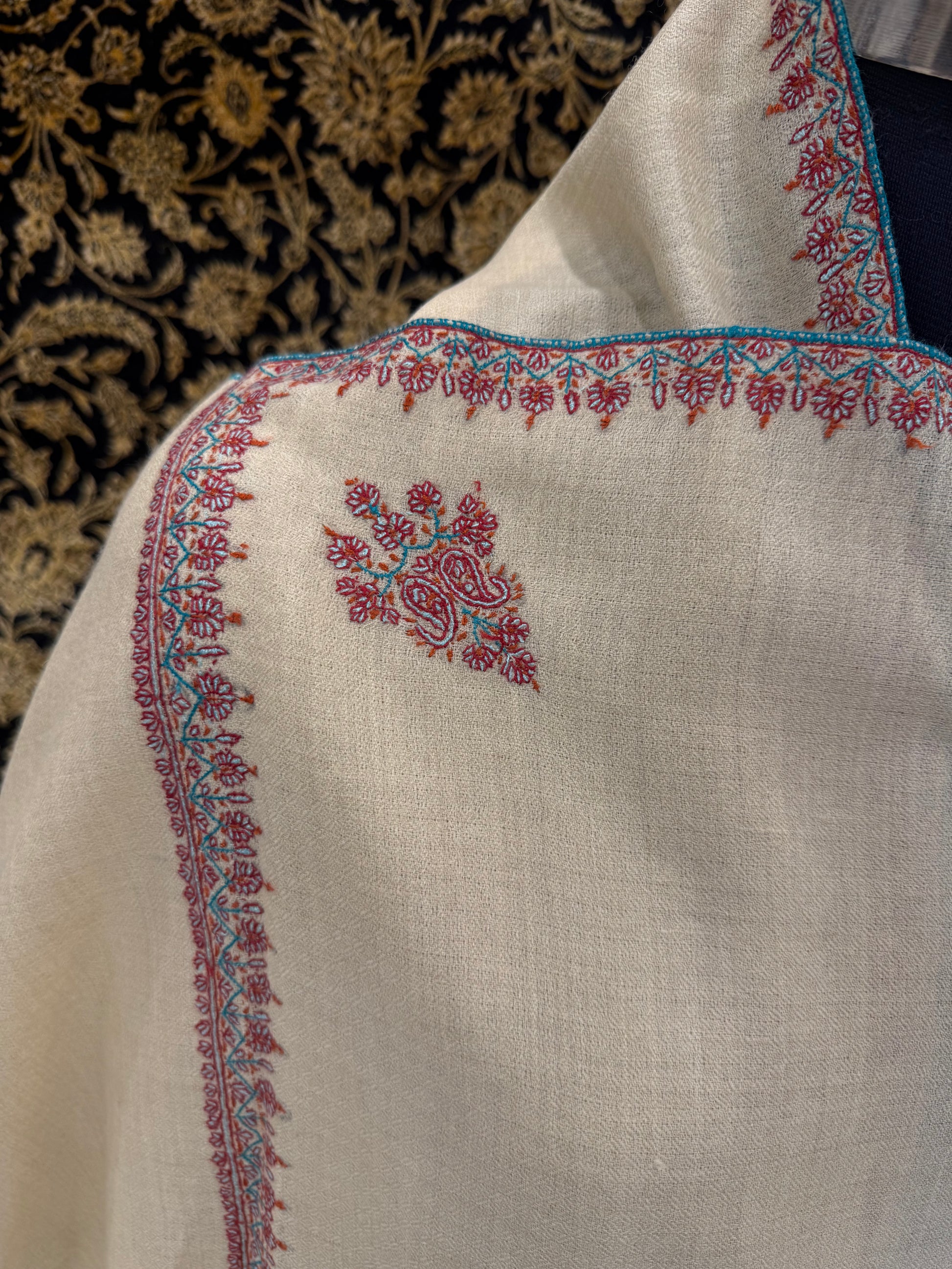 Close-up of a piece of fabric with intricate embroidery on a textured background